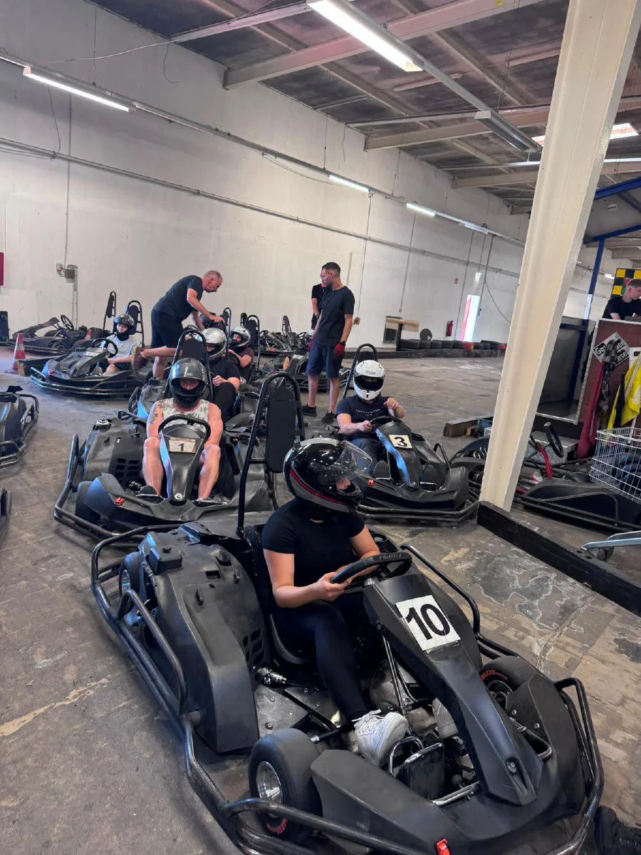 Gruppe mit Helmen in den Karts vor dem Start in der Indoor Kartbahn Kassel